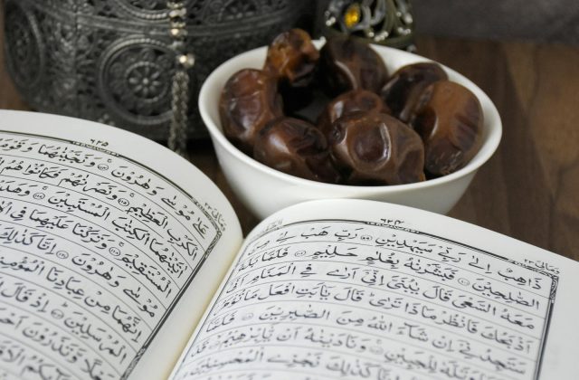 An open Quran with a bowl of dates, symbolizing Ramadan and Islamic traditions.