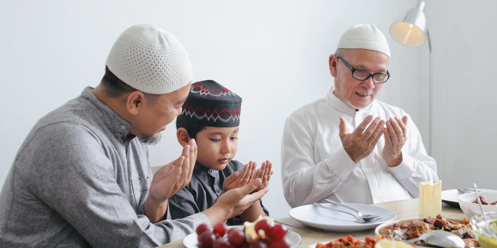 Father Teaching Son To Praying Dua Before Eating Special Dish On Eid Al Fitri Moment